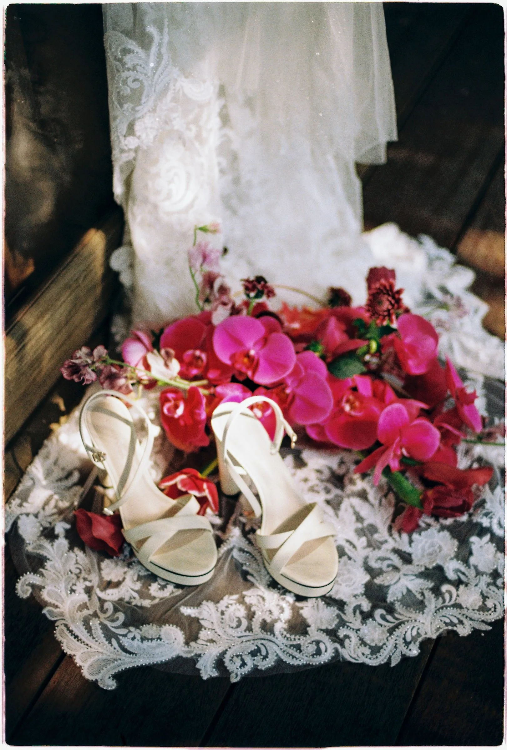 Bridal heels and a magenta orchid bouquet on lace, shot on film