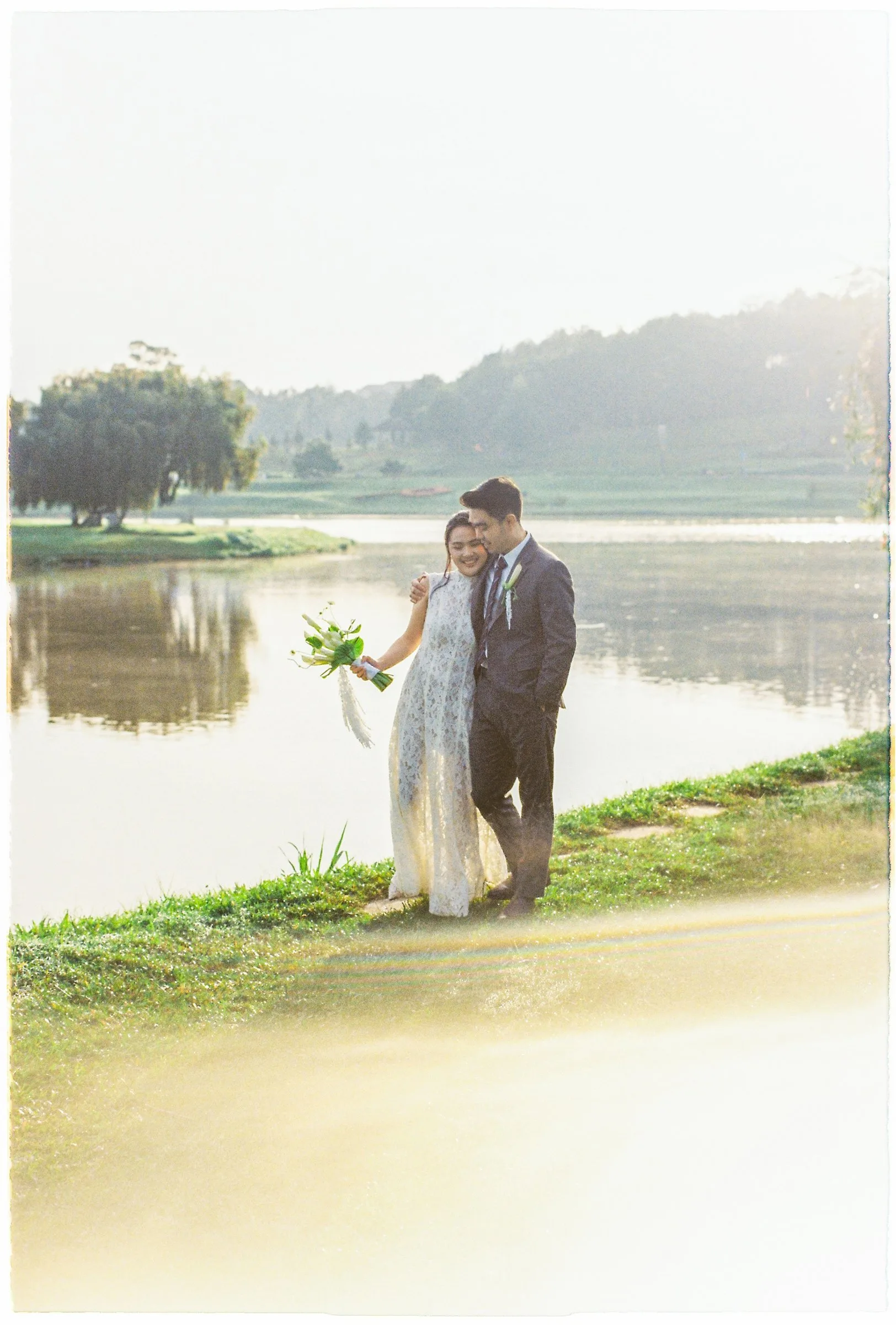 Couple kissing by Xuan Huong Lake at golden hour, Da Lat pre-wedding on film