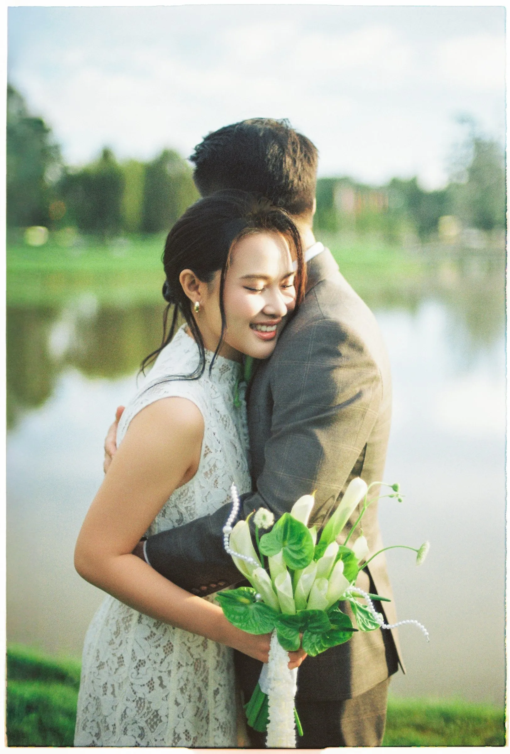 Couple embracing with calla lilies in a warm film-style Da Lat pre-wedding shoot