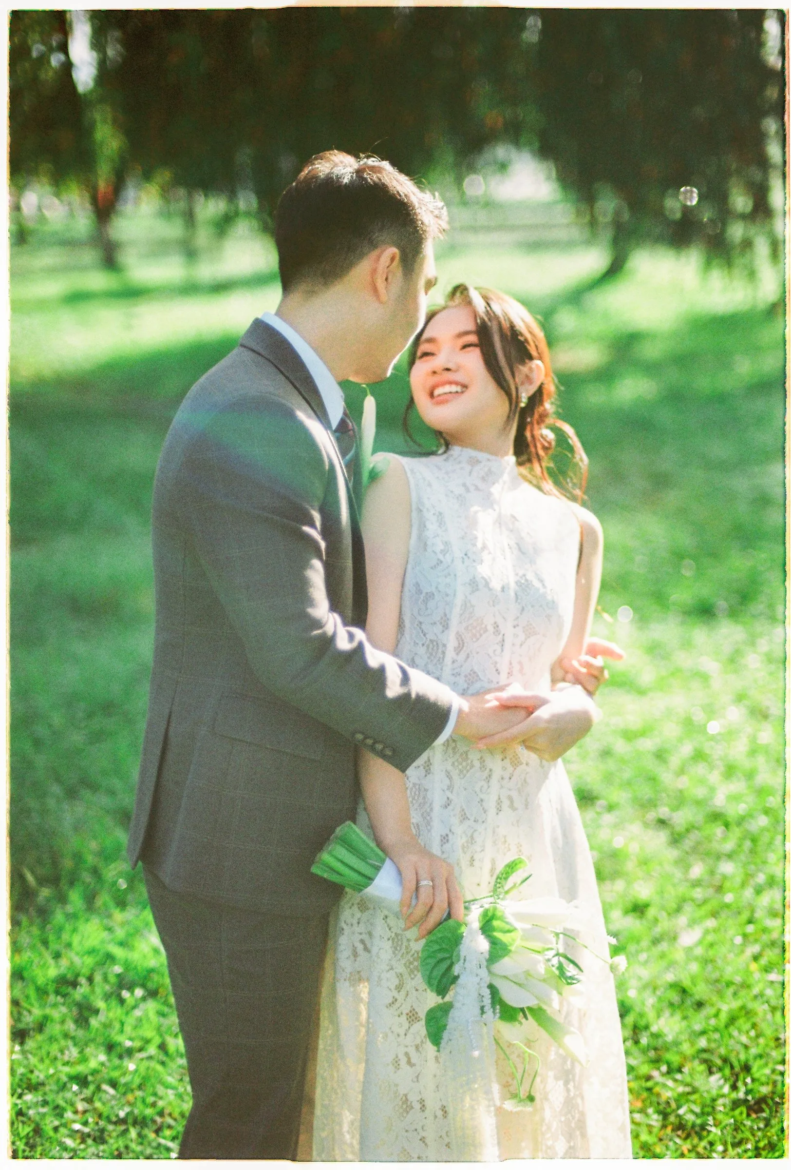 Couple laughing together in a green Da Lat field during their pre-wedding
