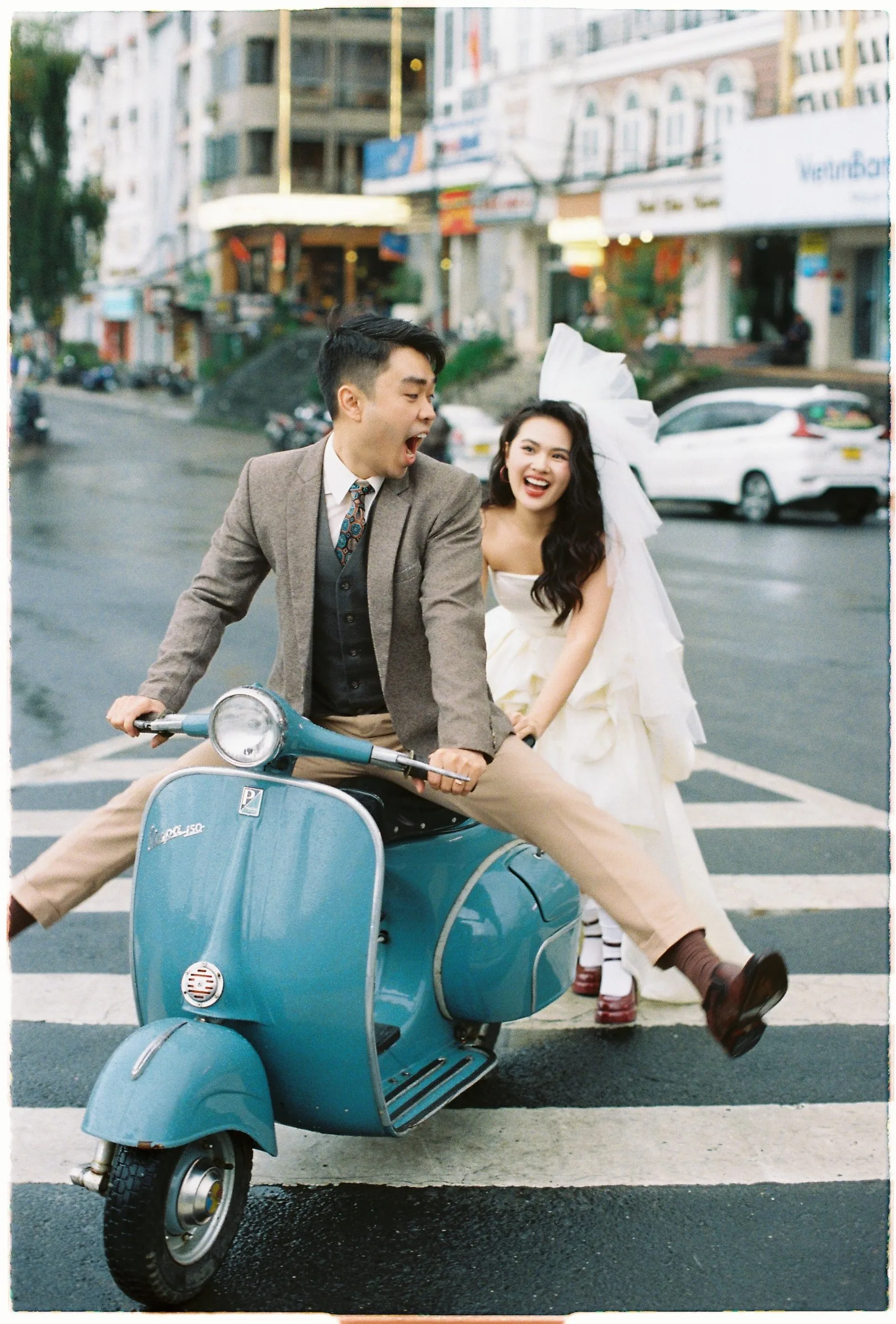 Couple on a vintage Vespa in the old streets of Da Lat