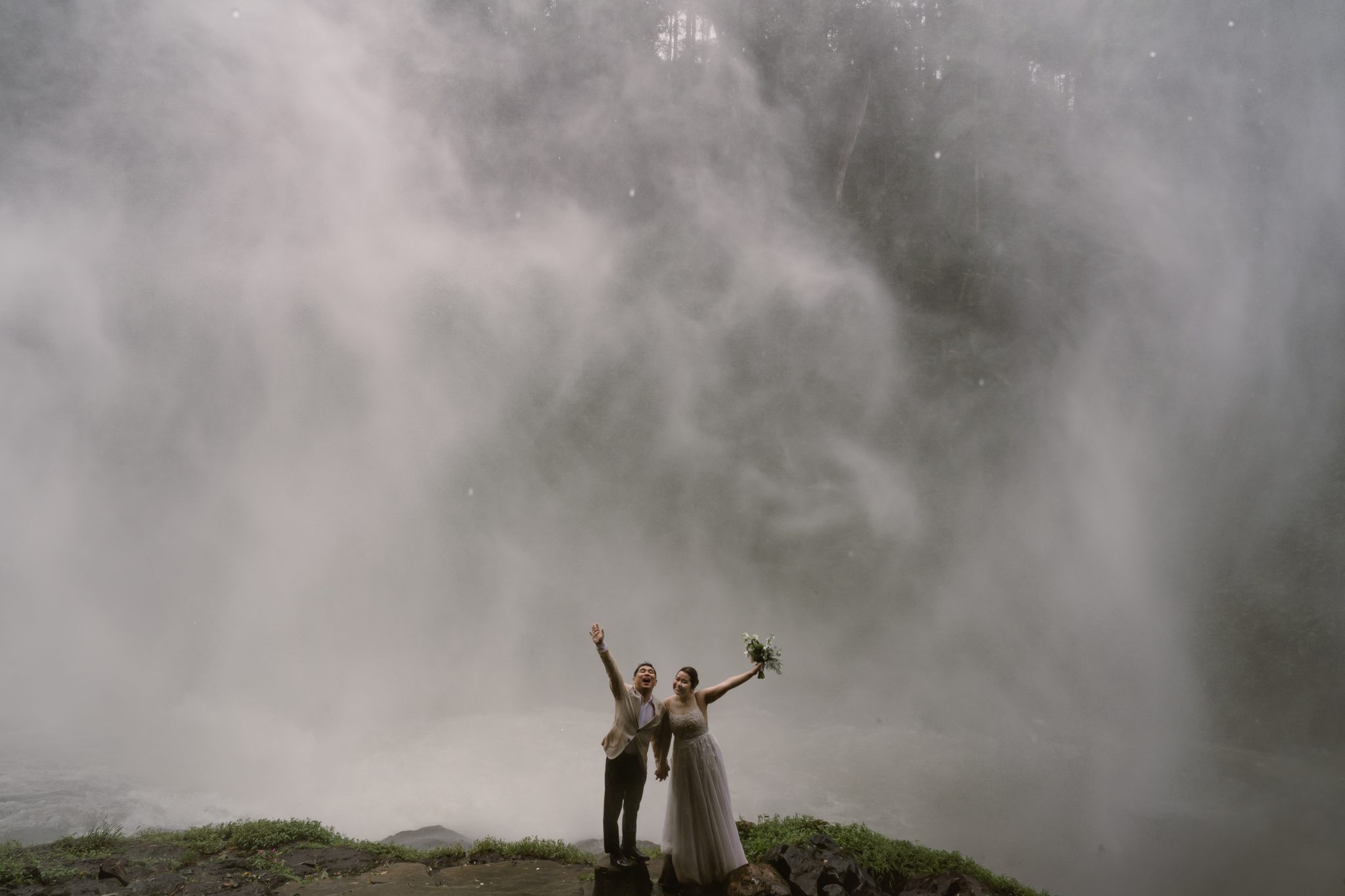 Arms up, laughing, completely soaked. This is what an adventure elopement feels like.