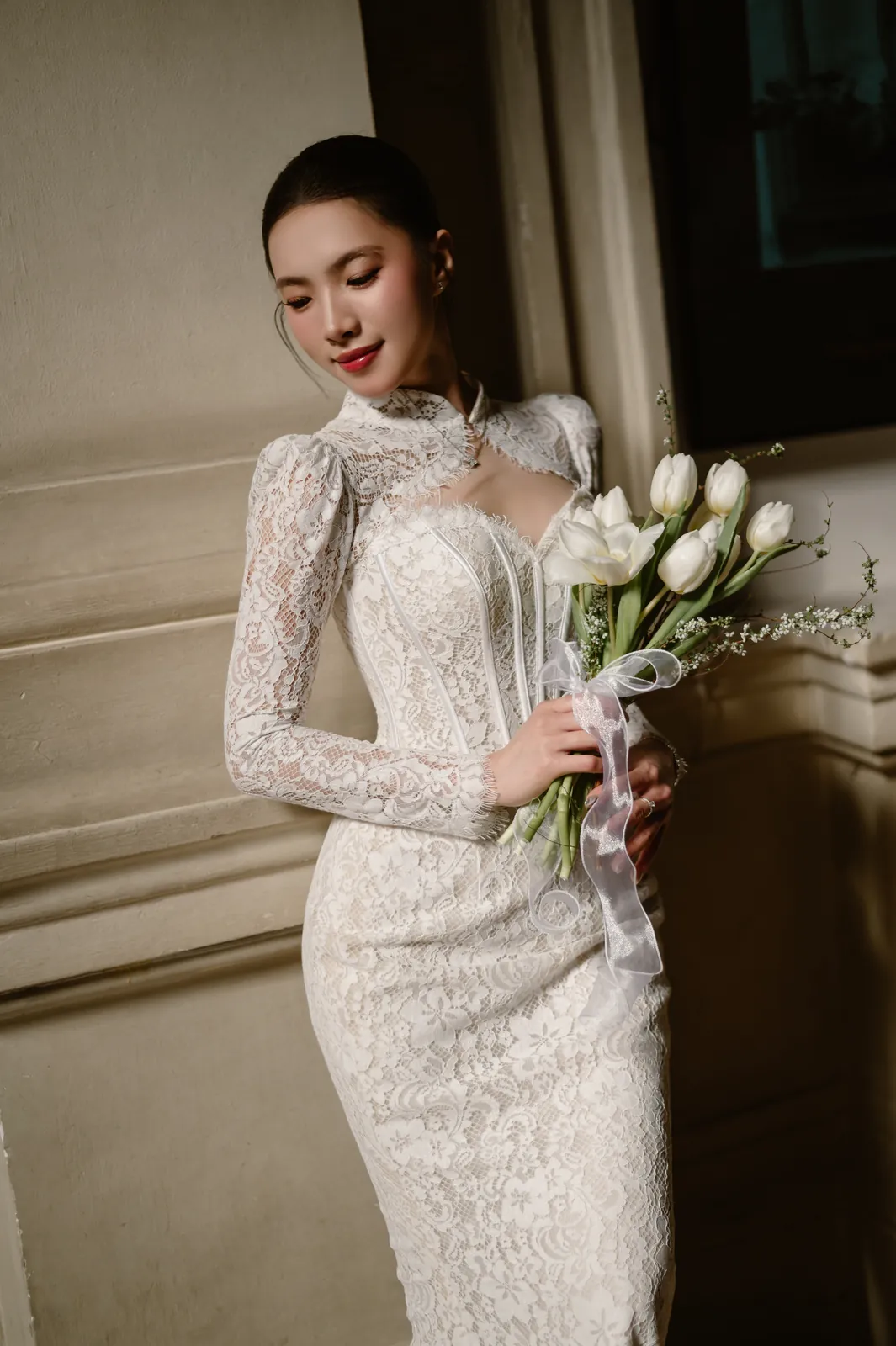 A bride in a lace gown with white tulips