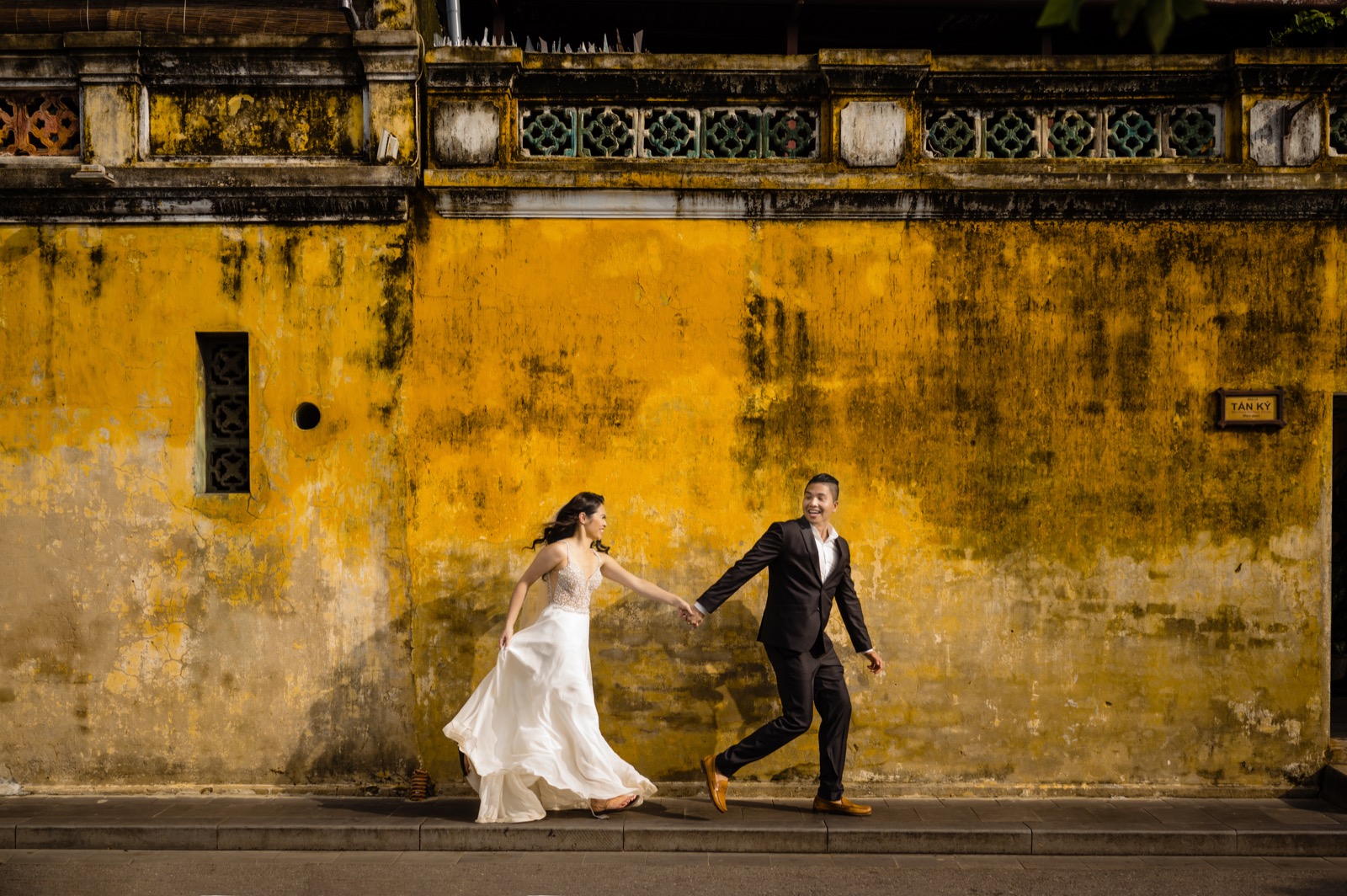 Running along one of Hoi An's famous weathered yellow walls.
