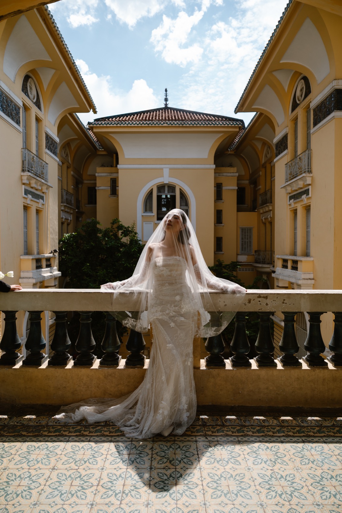 Bride in a flowing veil on the balustrade of the Ho Chi Minh City Fine Arts Museum, Saigon