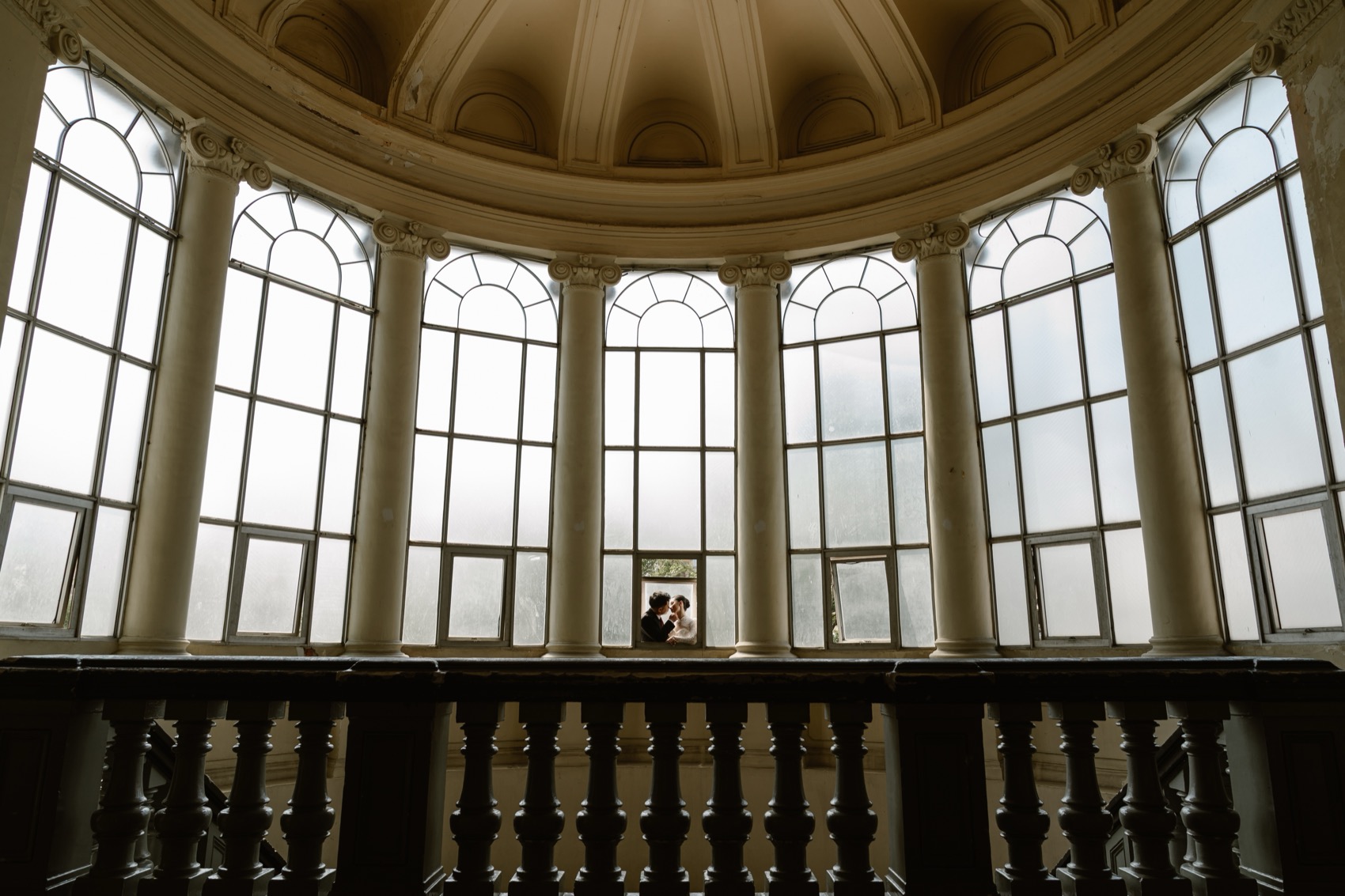 Couple beneath the grand dome of a colonial building in Ho Chi Minh City