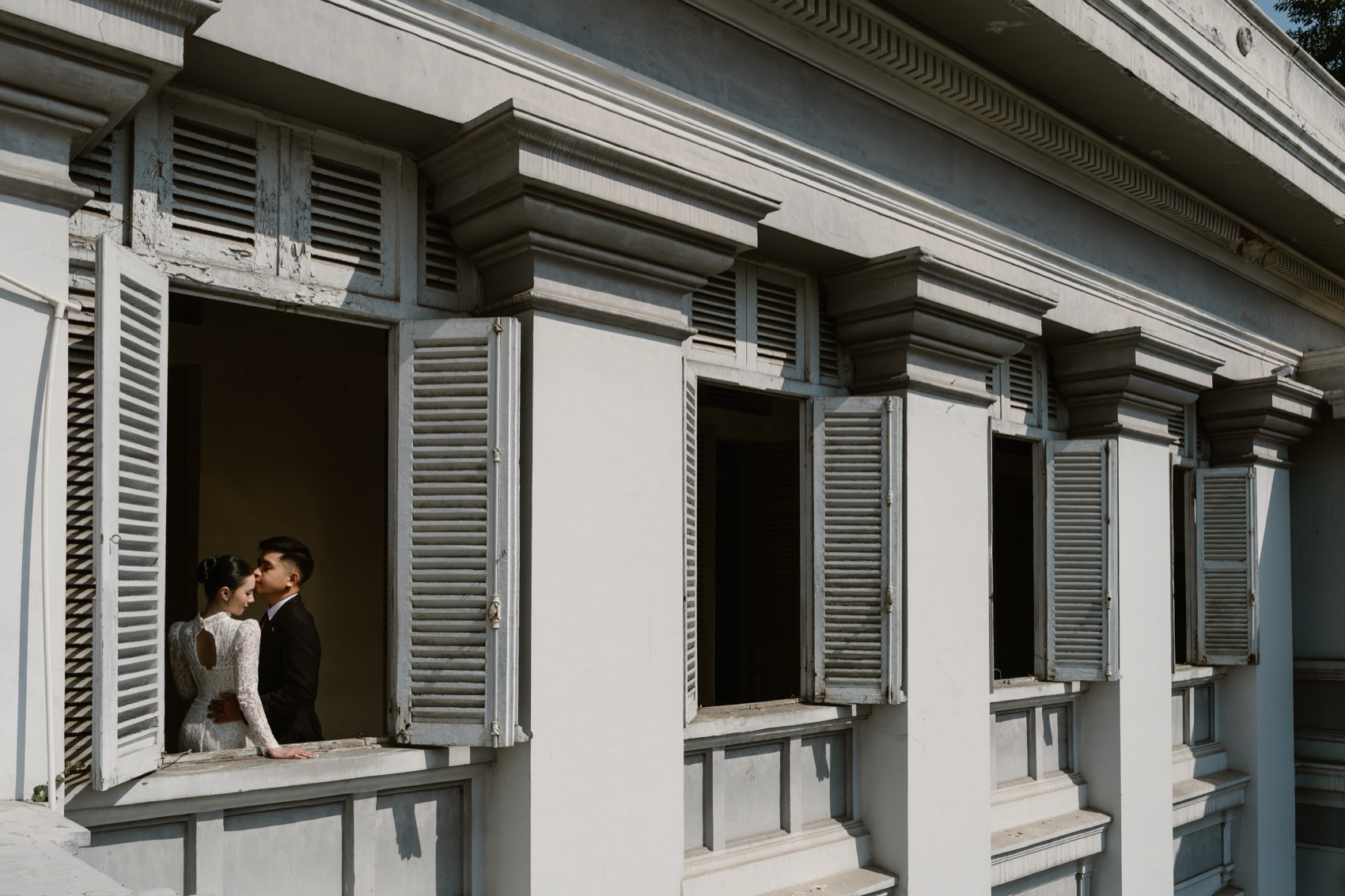 Couple in a shuttered window of the Fine Arts Museum, Ho Chi Minh City
