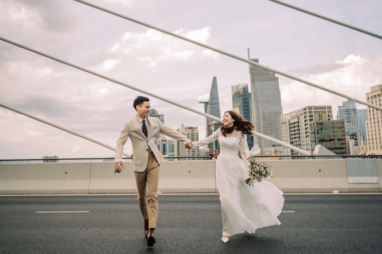 Running hand in hand across the bridge, veil flying.