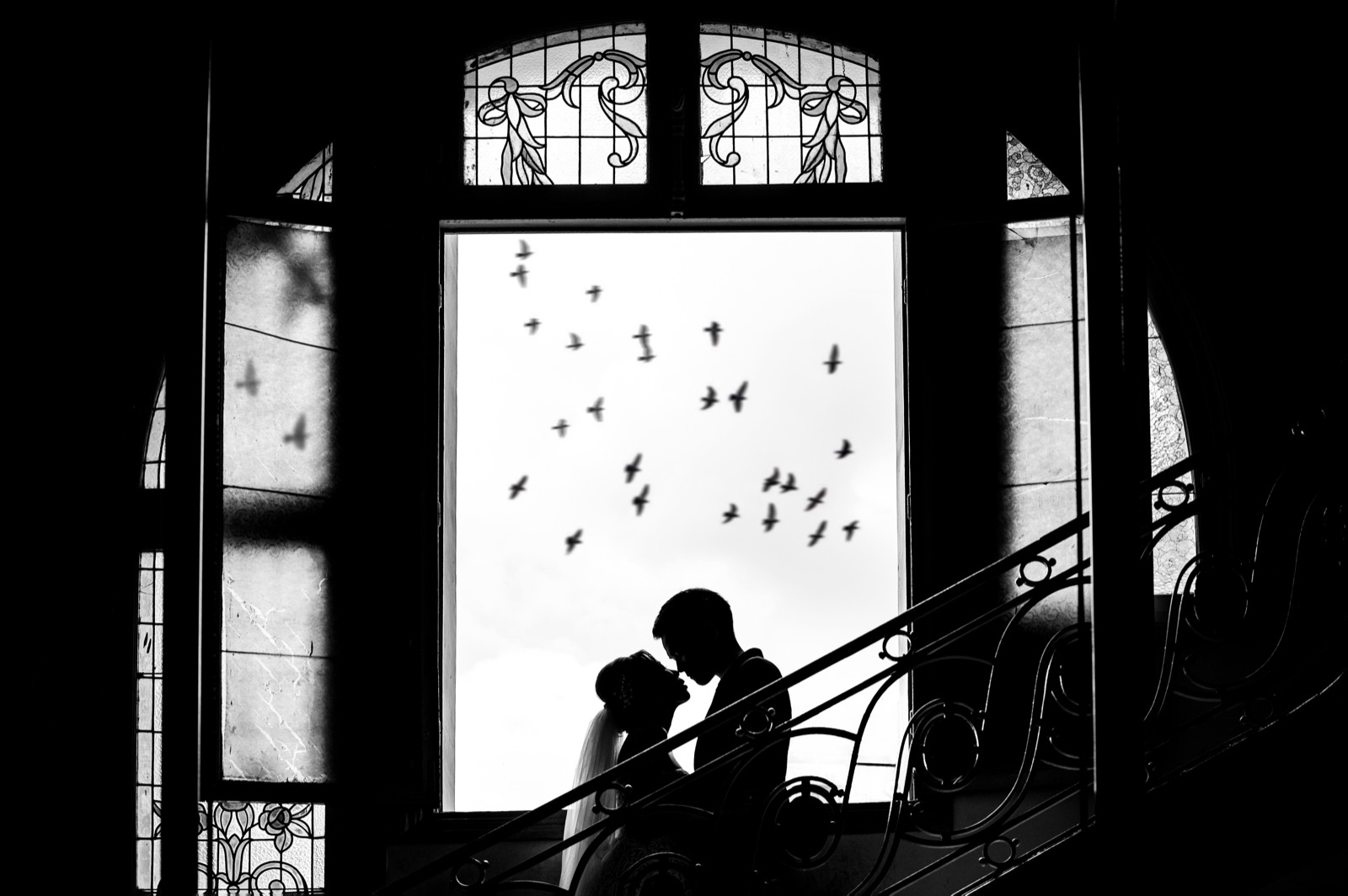 A silhouette on the museum stairs against the old windows.