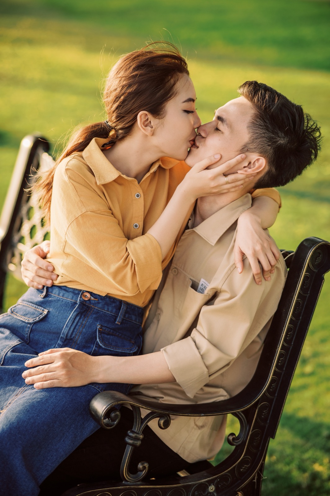 A kiss on a park bench, easy and unposed.