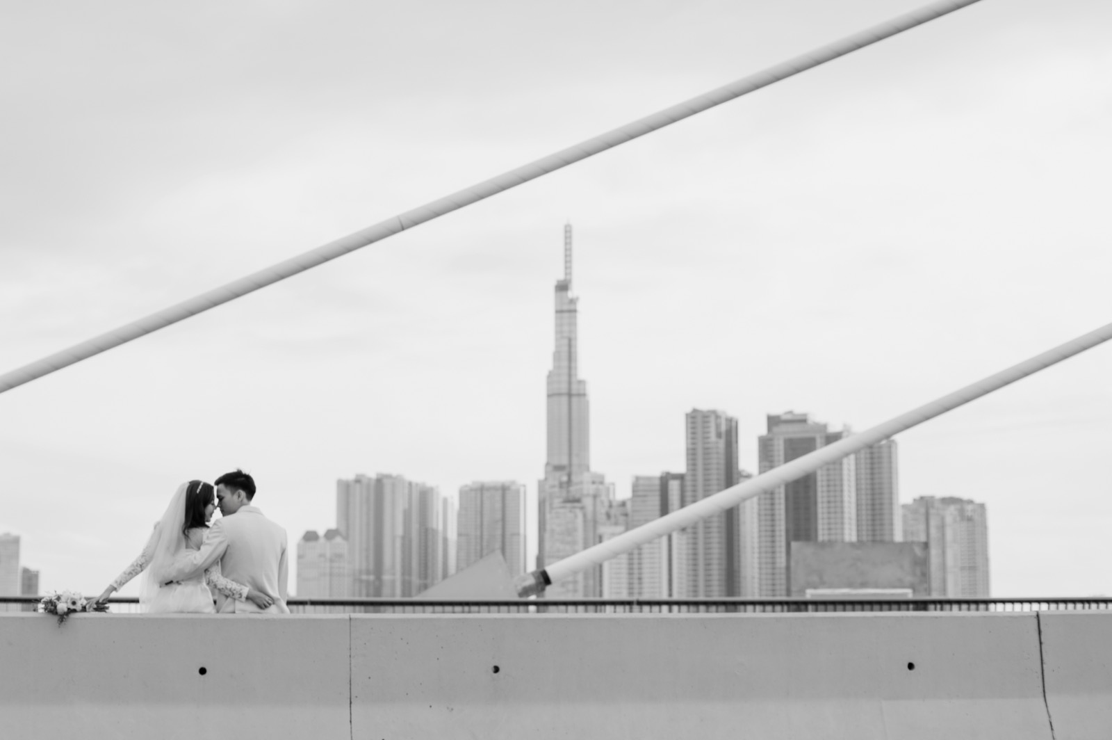 Black and white, with Landmark 81 rising behind them.