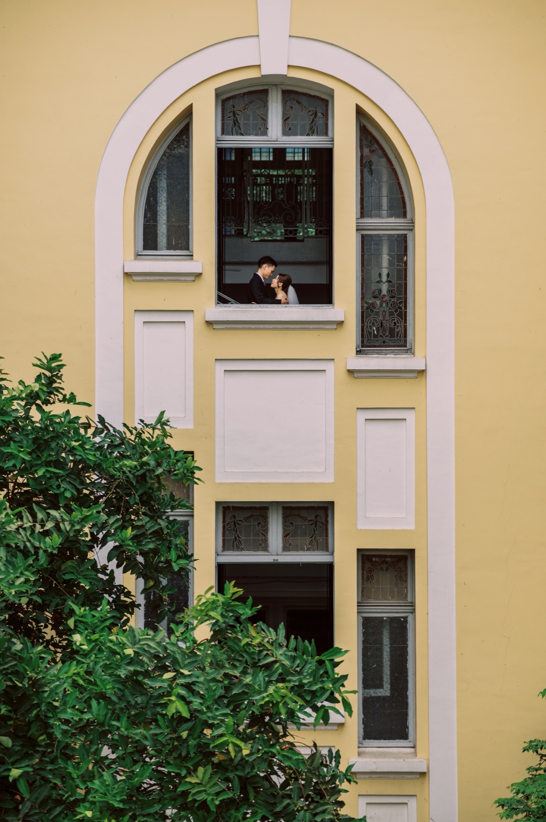 A playful moment at a yellow colonial window.
