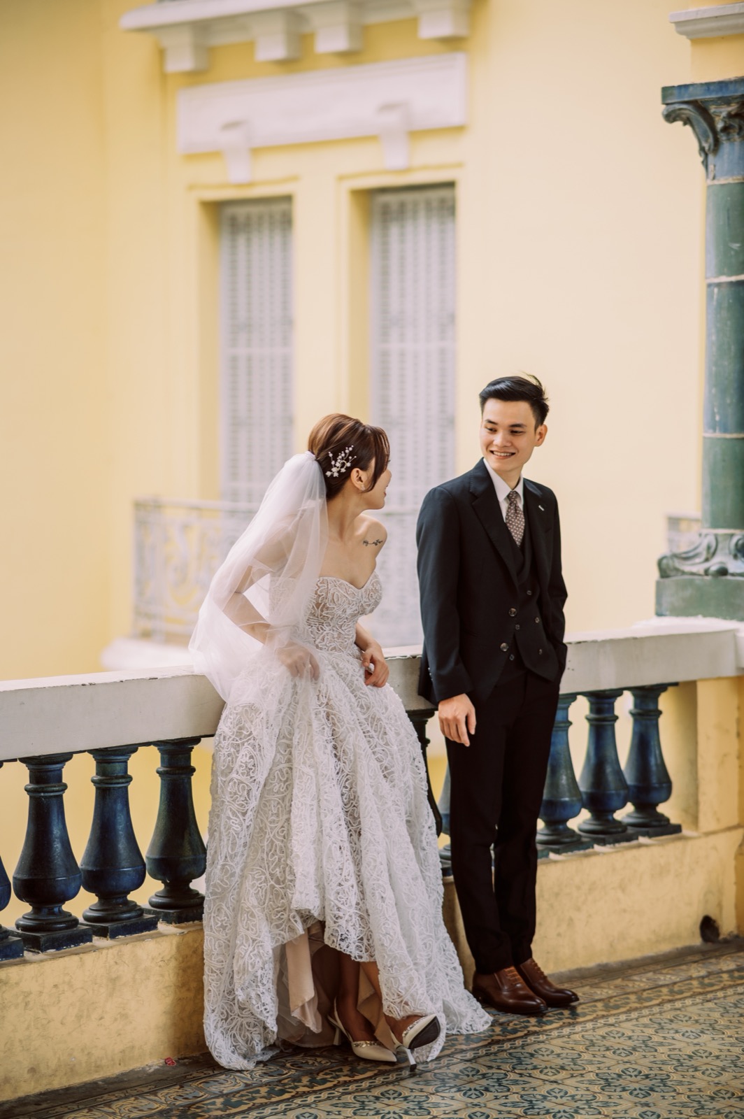 On the museum balustrade, sharp in a dark suit.