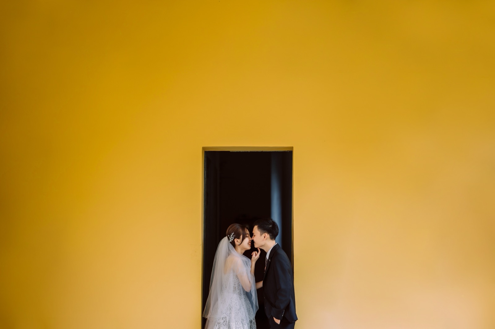 A kiss in the museum's minimalist yellow doorway.