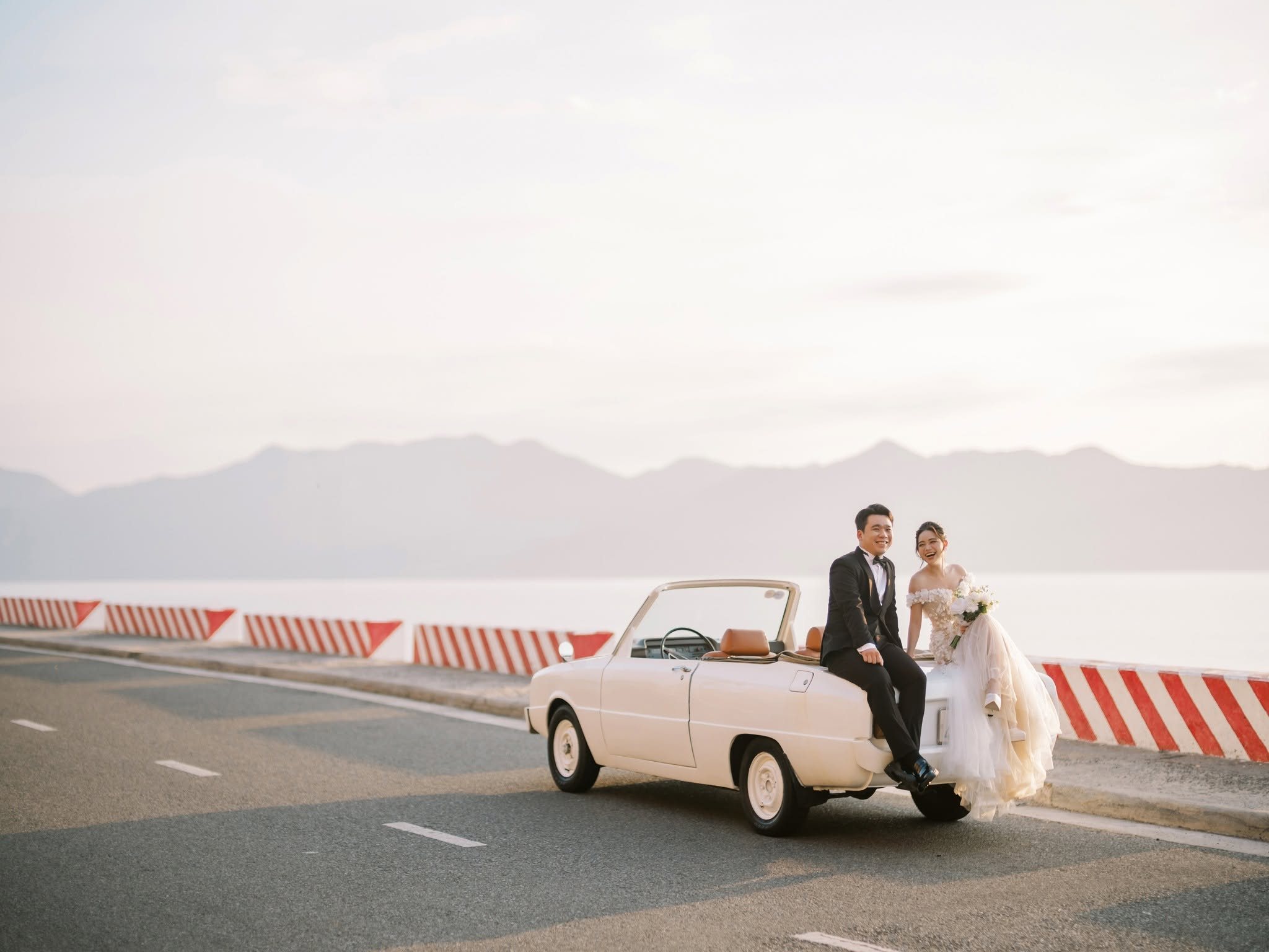 The vintage car on the empty coastal road above Nha Trang bay.