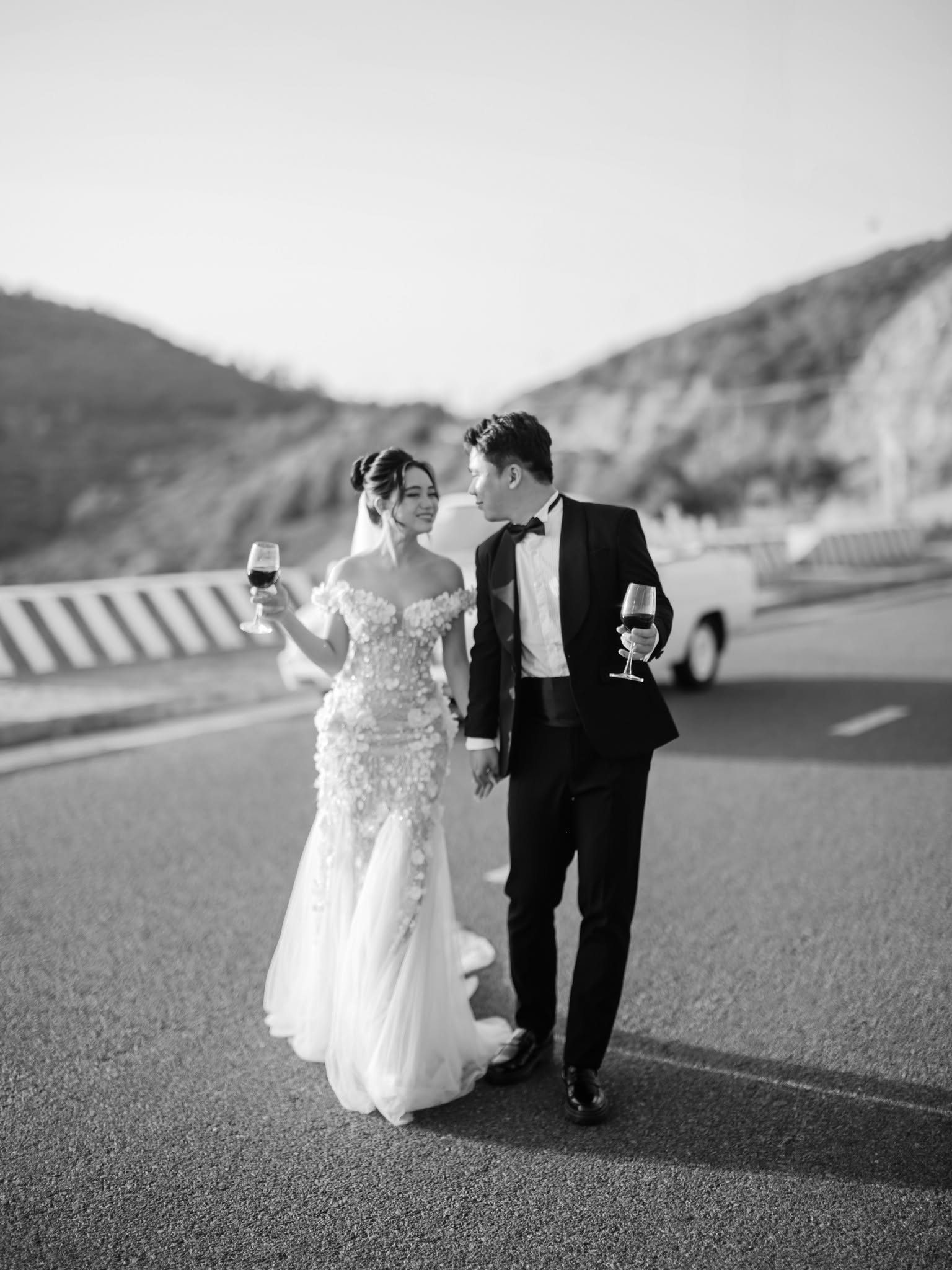 On foot beside the car, in black and white.