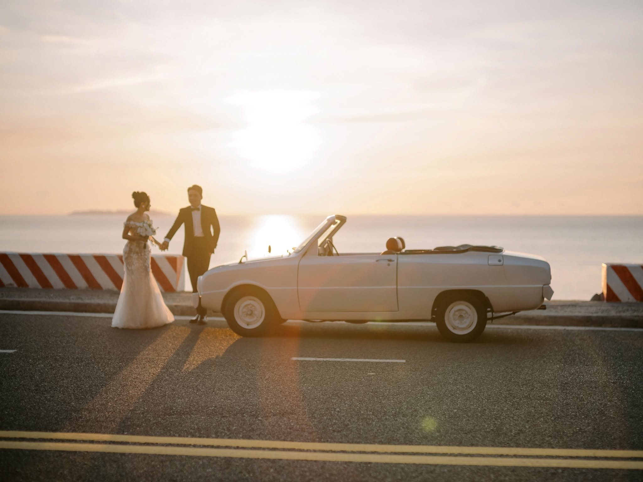 Trung & Chung against the first light, the classic car beside them.