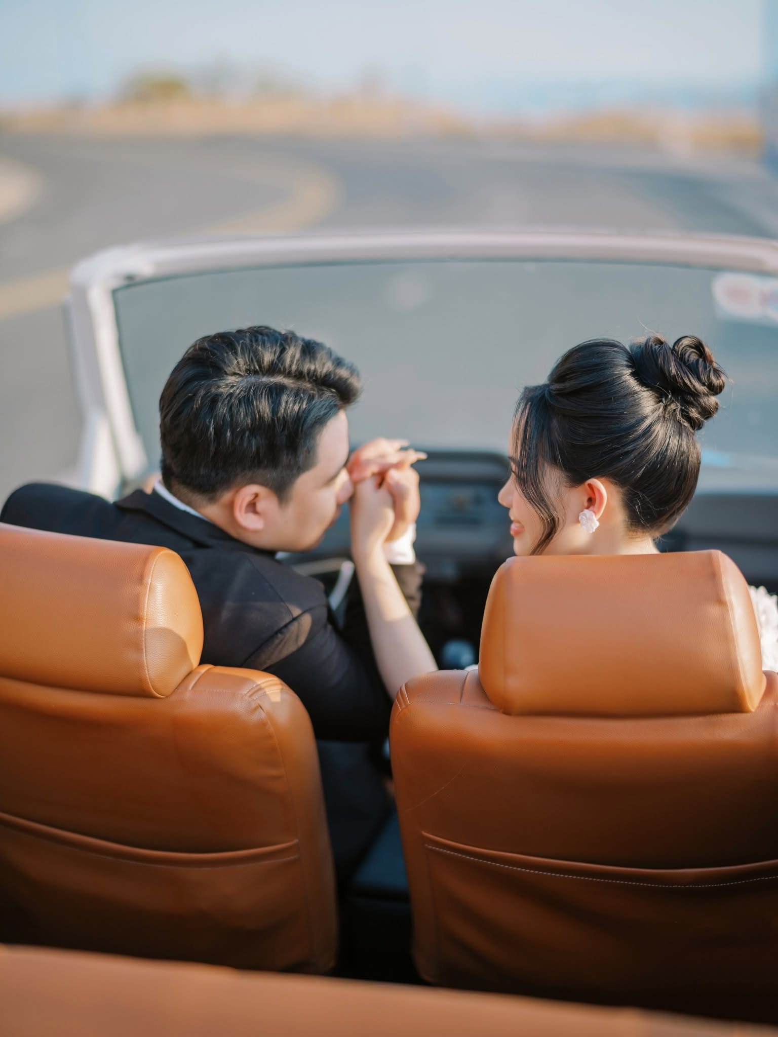 A hand lifted and kissed across the front seats.