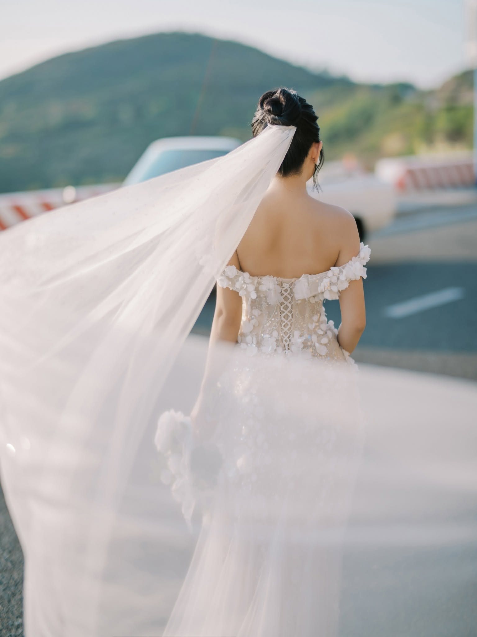 The veil catching the sea breeze on the coastal road.