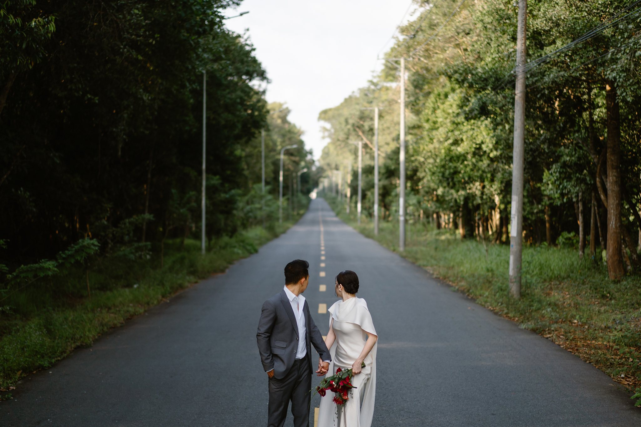 The long, straight road cutting through the trees, a Ho Tram signature.