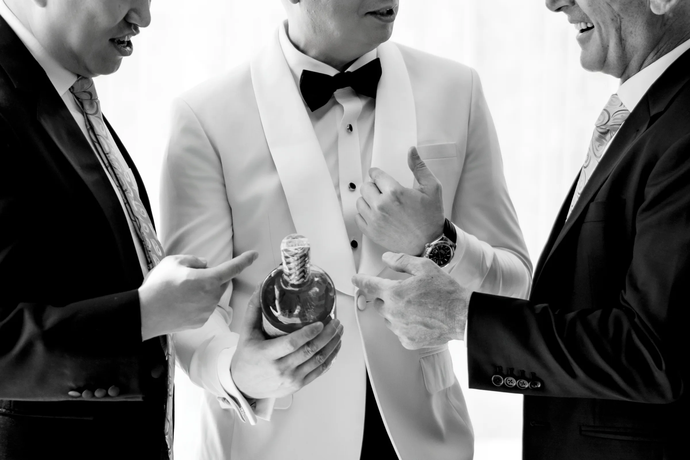Black and white candid of the groom and guests before a Ho Tram wedding
