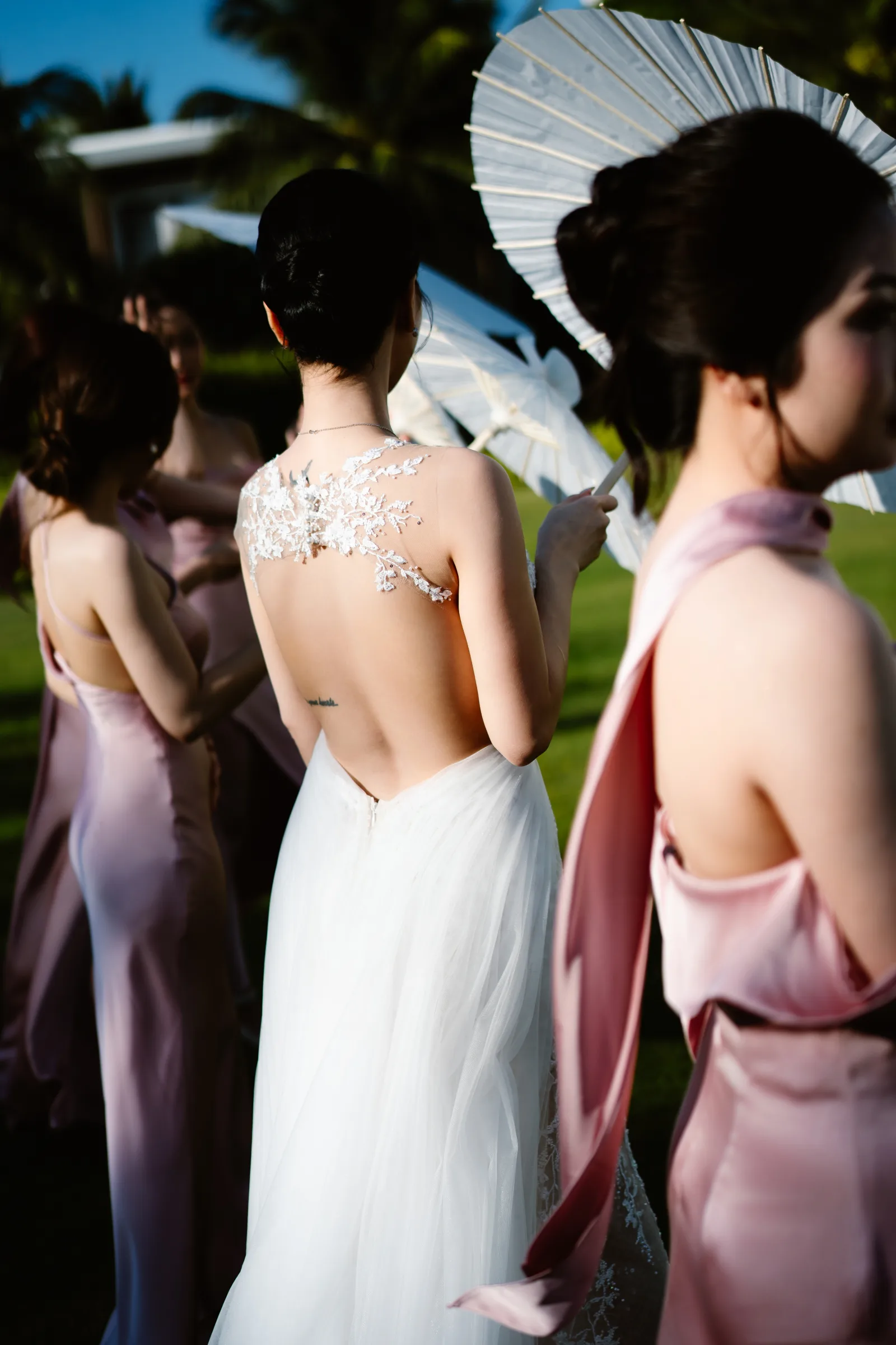 A bride with a parasol and her bridesmaids at a beach resort wedding in Vietnam by TIMO Wedding
