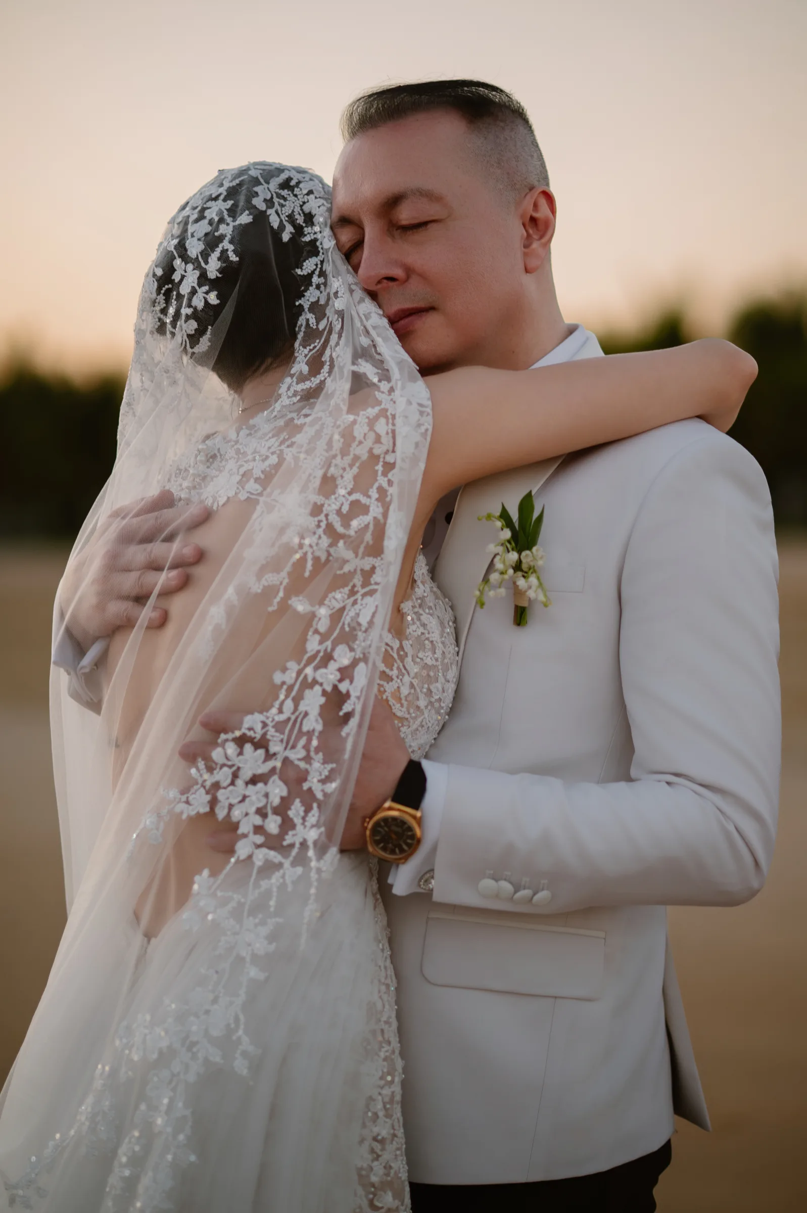 A couple embracing on the beach at golden hour, Melia Ho Tram, Vietnam
