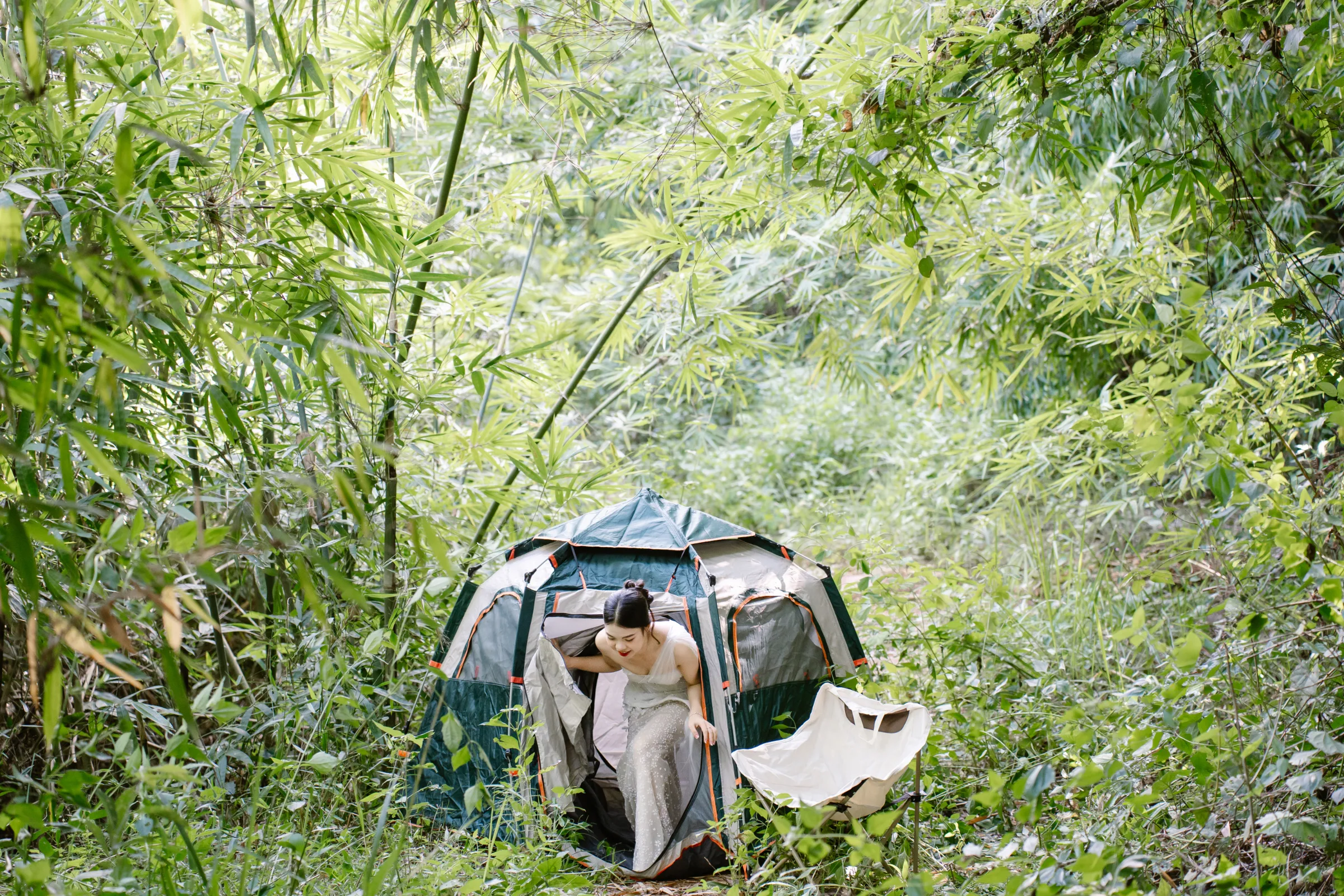 Couple by a tent in the forest during an adventure elopement in Dak Nong