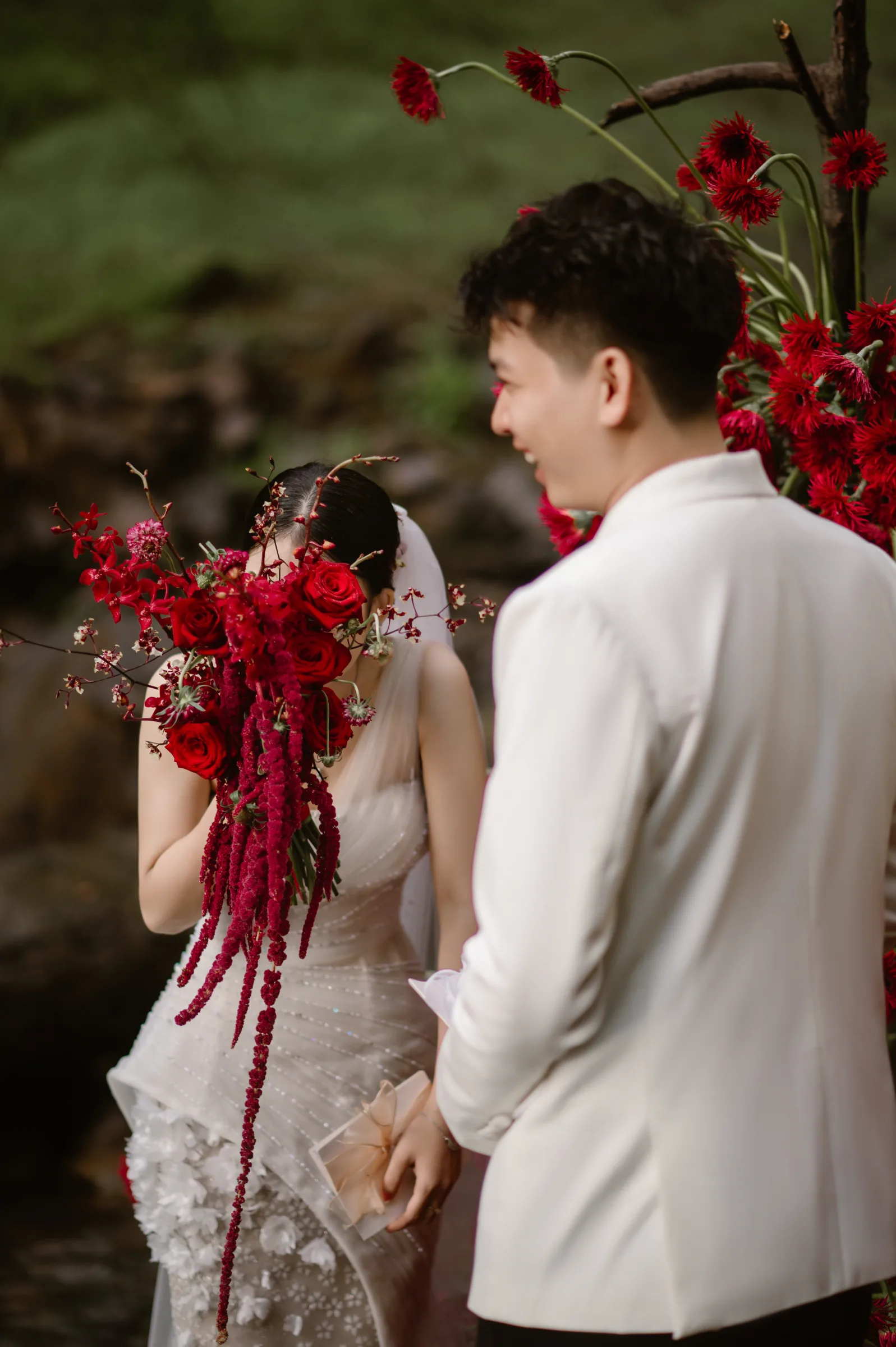 Couple laughing, the bride in a red floral veil, at an elopement in the Central Highlands