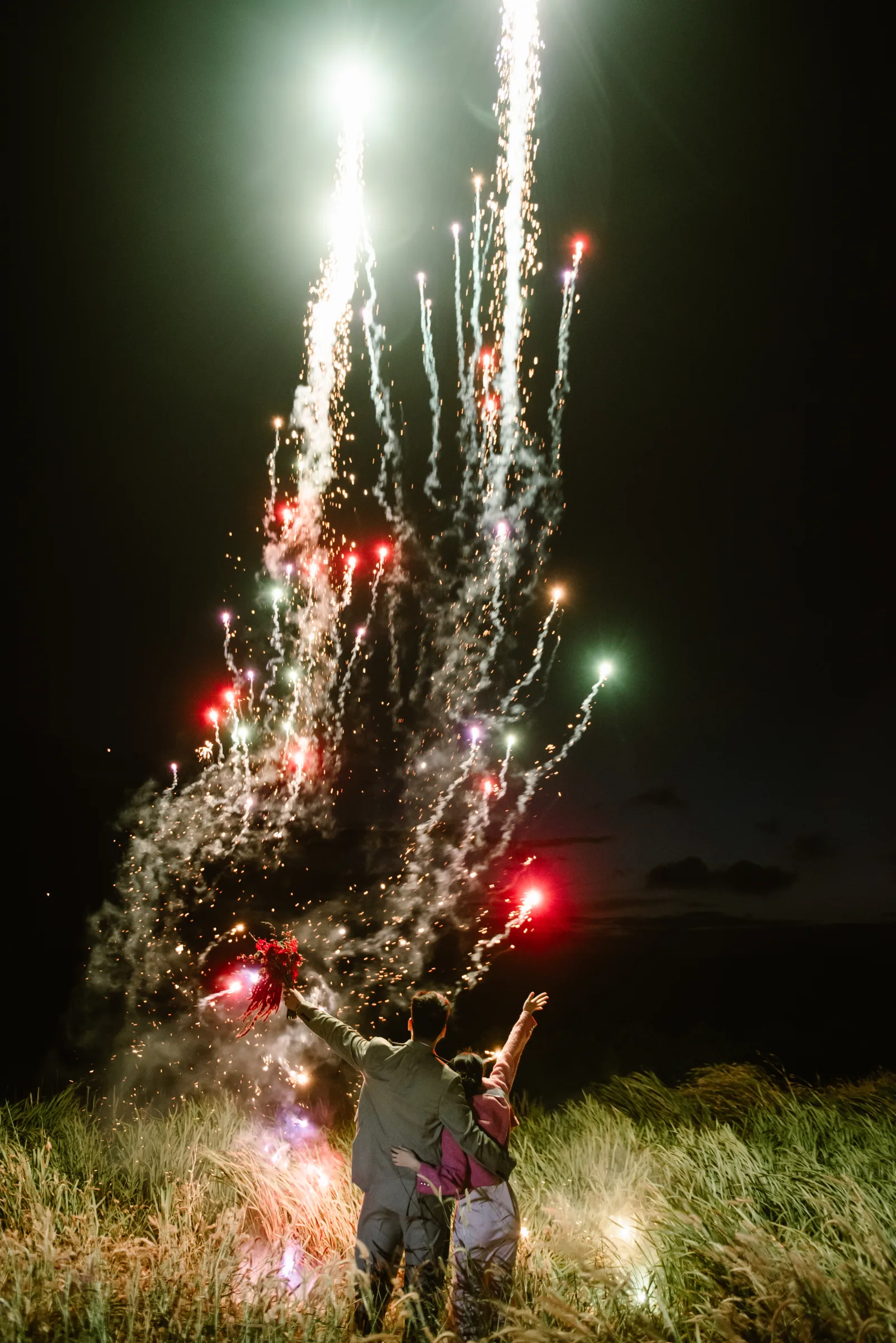 Couple with fireworks at night to celebrate their Vietnam elopement
