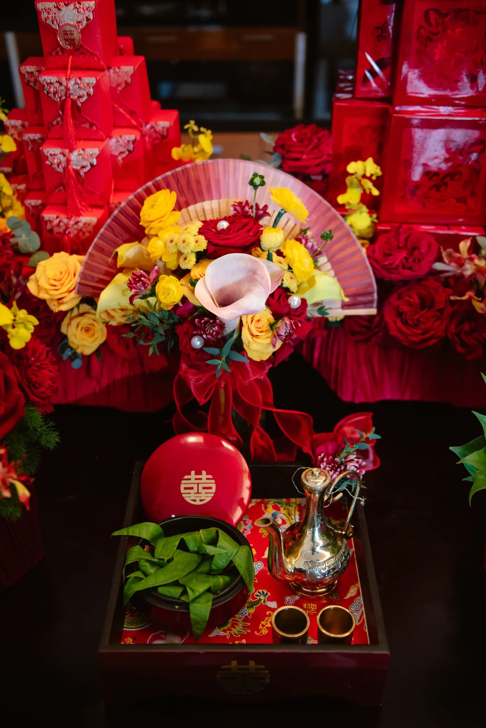 Red lacquer boxes, gold wedding rings, betel leaves and flowers laid out on the ceremonial trays for a Vietnamese wedding.