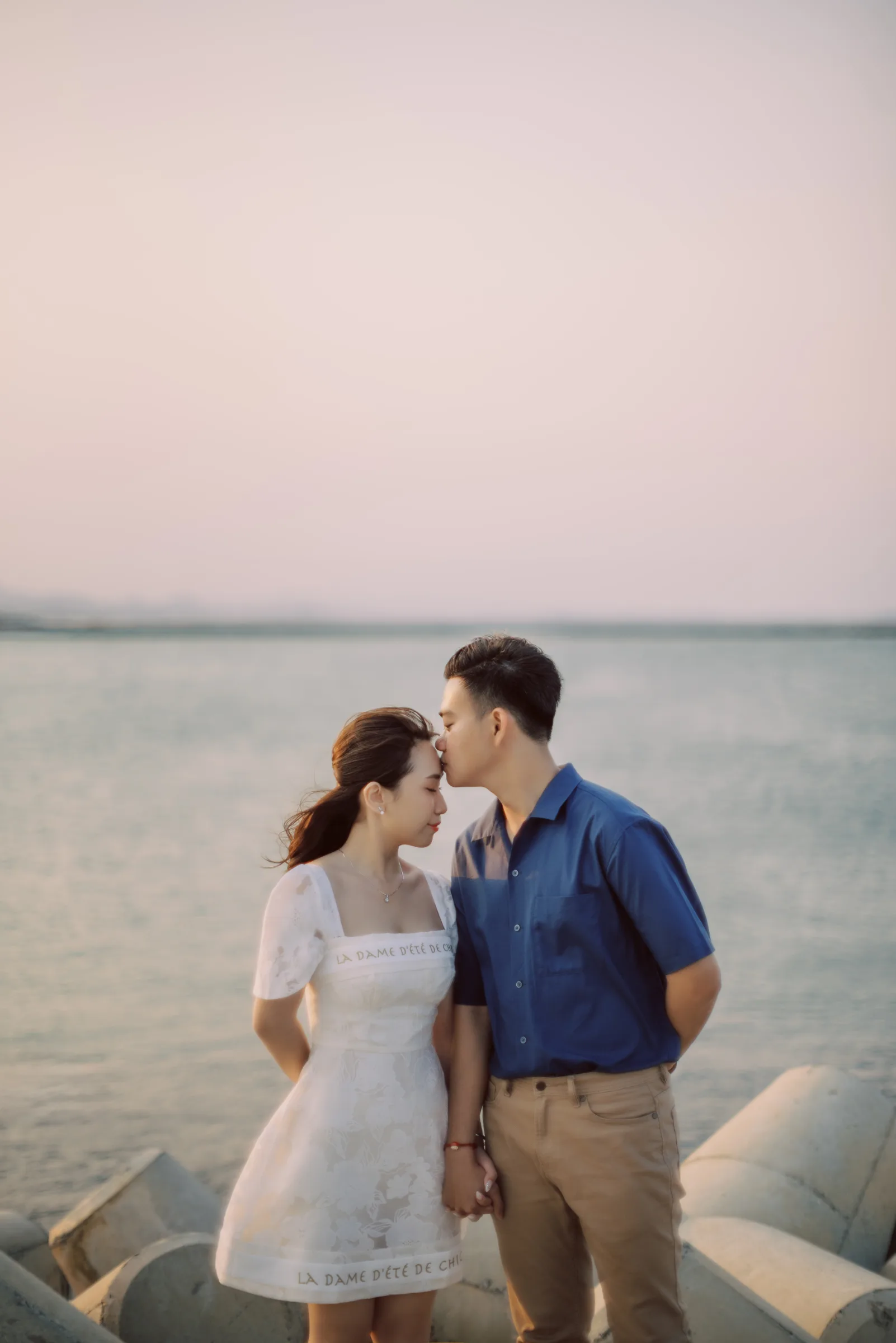 A tender forehead kiss by the sea at a Phu Yen pre-wedding