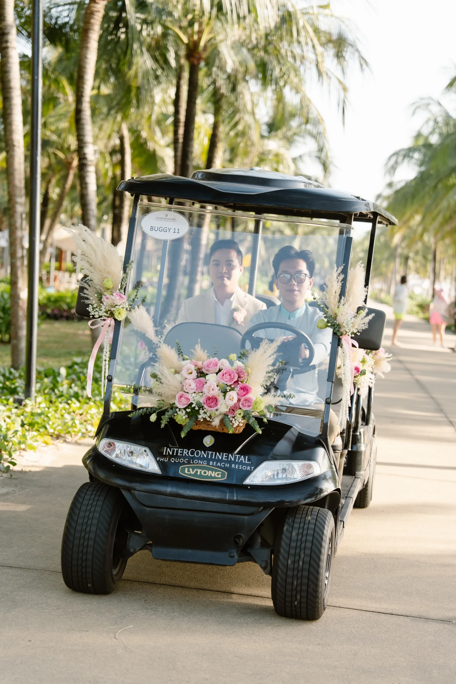 The couple on a flower-decorated resort buggy at InterContinental Phu Quoc